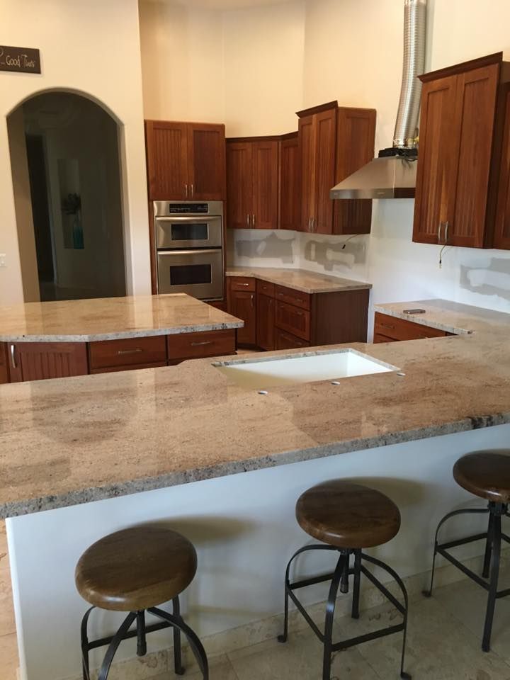 A kitchen with granite counter tops and wooden cabinets