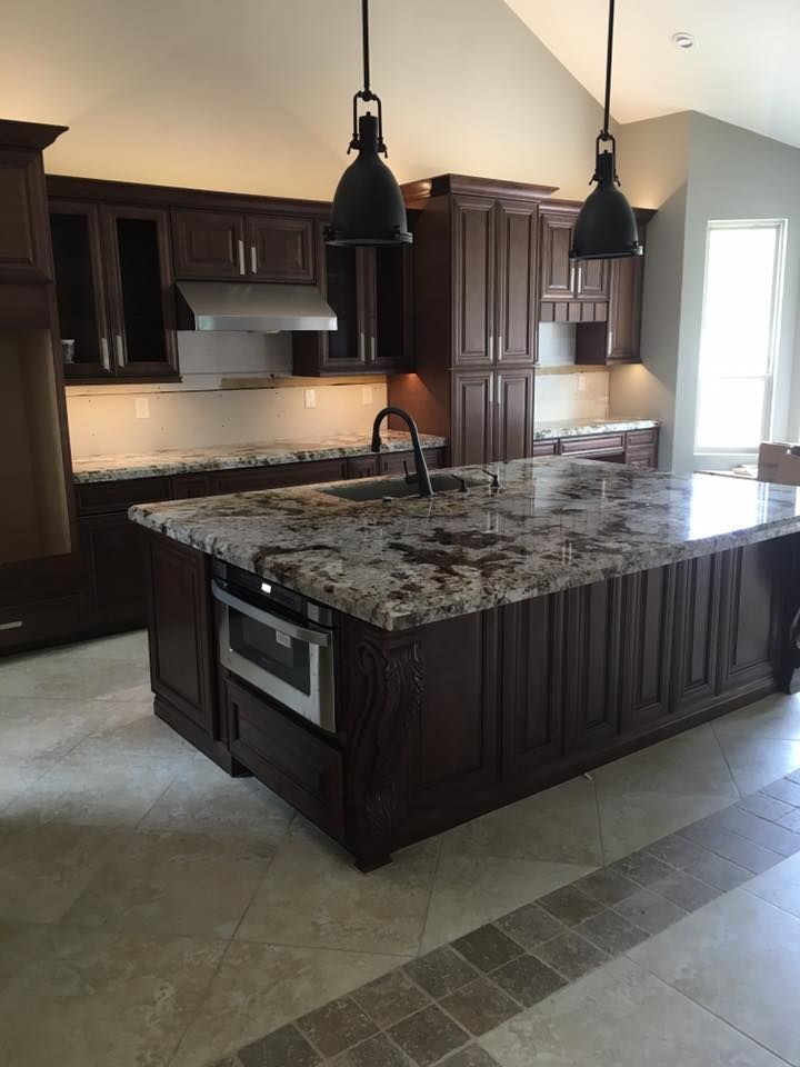 A kitchen with a large island and granite counter tops