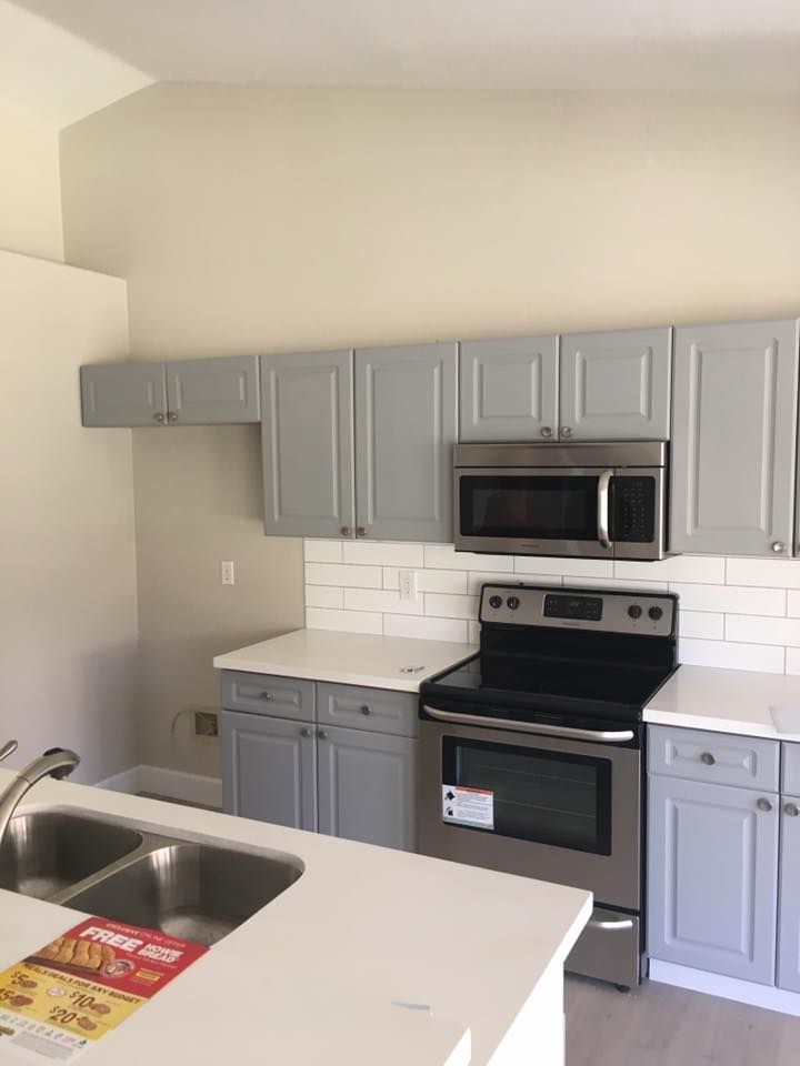 A kitchen with stainless steel appliances and gray cabinets