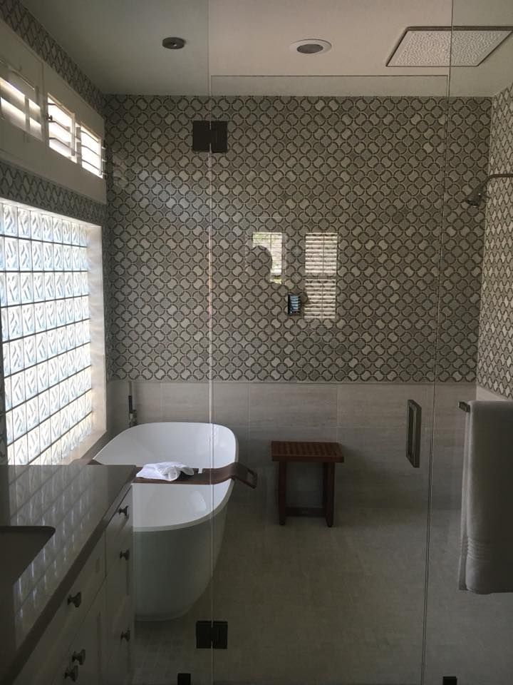 A bathroom with a bathtub and a glass shower door.