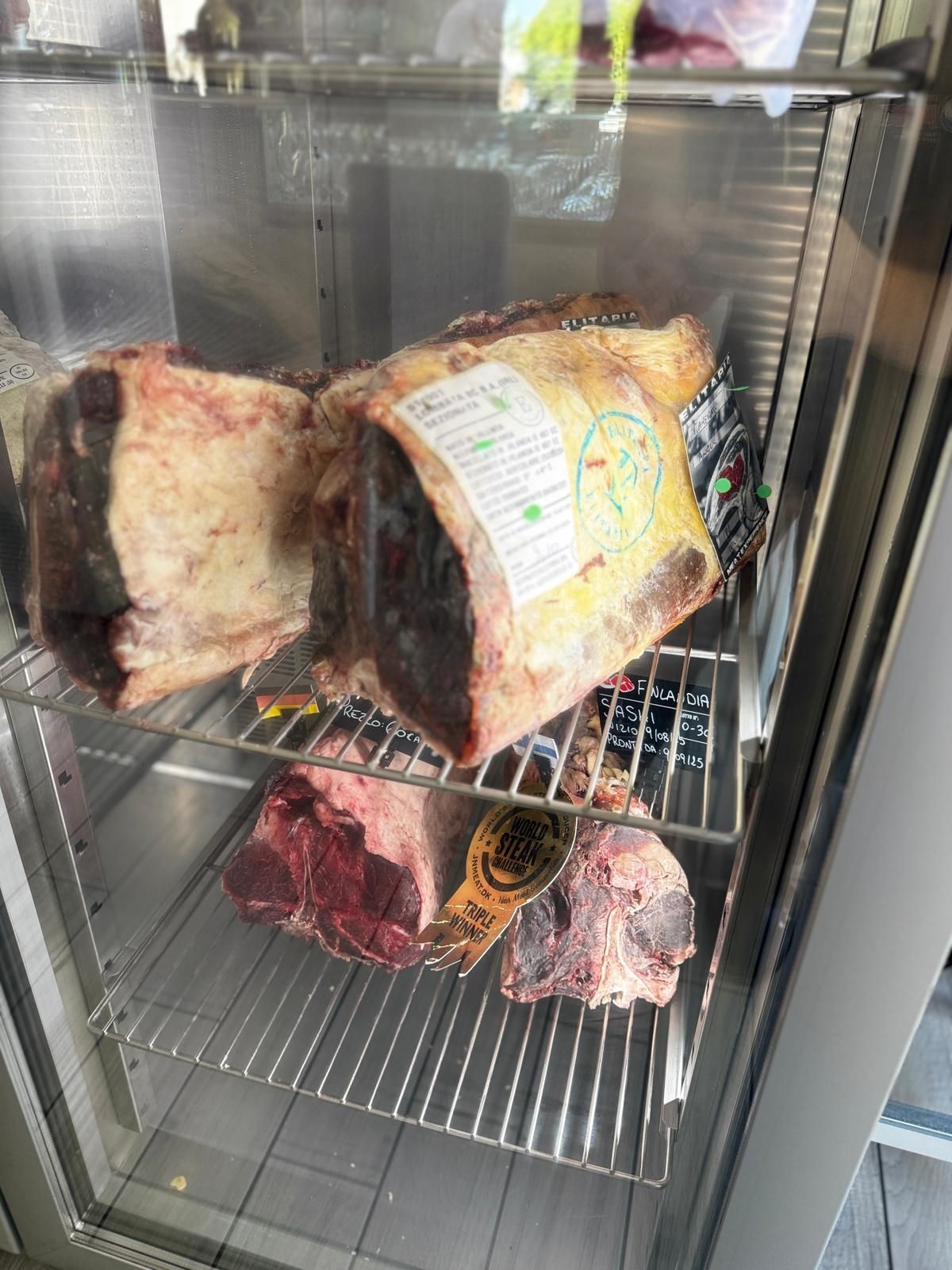 Vetrina con diversi tagli di carne di manzo cruda e stagionata.