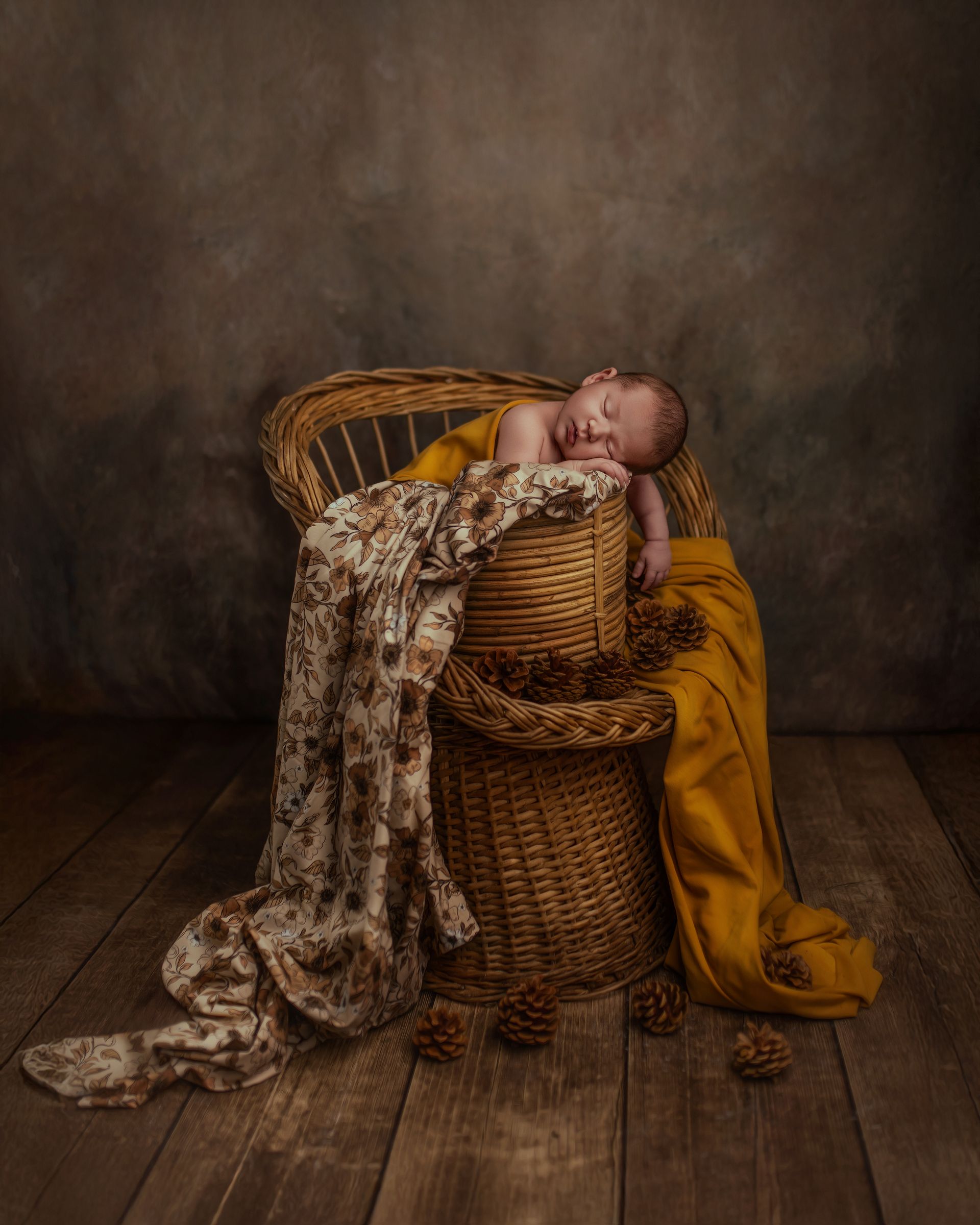 Un nouveau-né dort dans un panier en osier sur un plancher en bois.