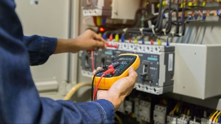 A Man Is Using a Multimeter to Test a Circuit Board - Hamilton, NZ - Hyperion Electrical