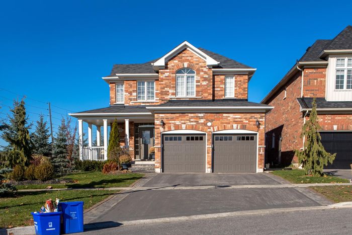 red and brown brick house with a concrete driveway