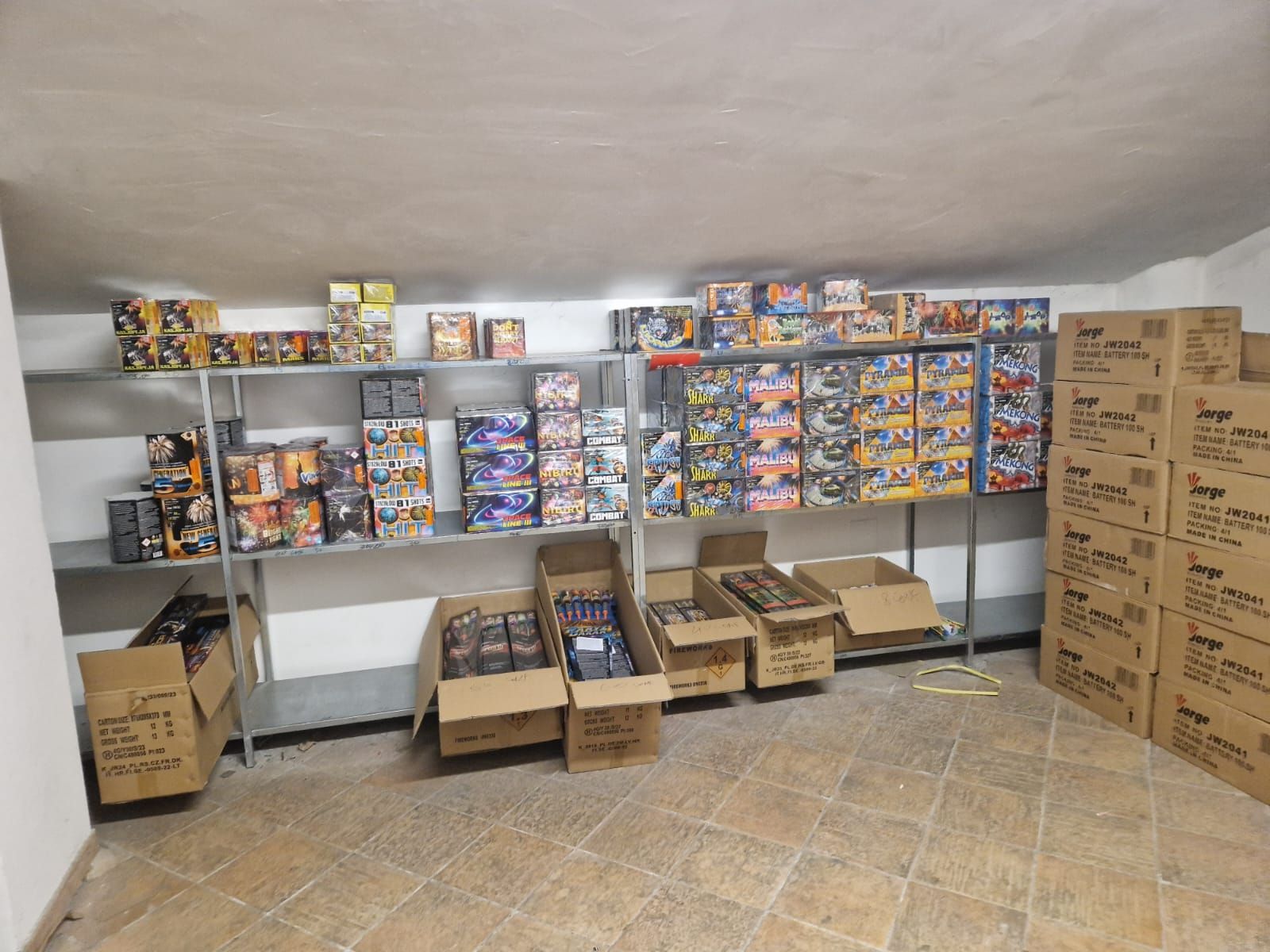 Una stanza piena di scatole e scaffali pieni di fuochi d'artificio