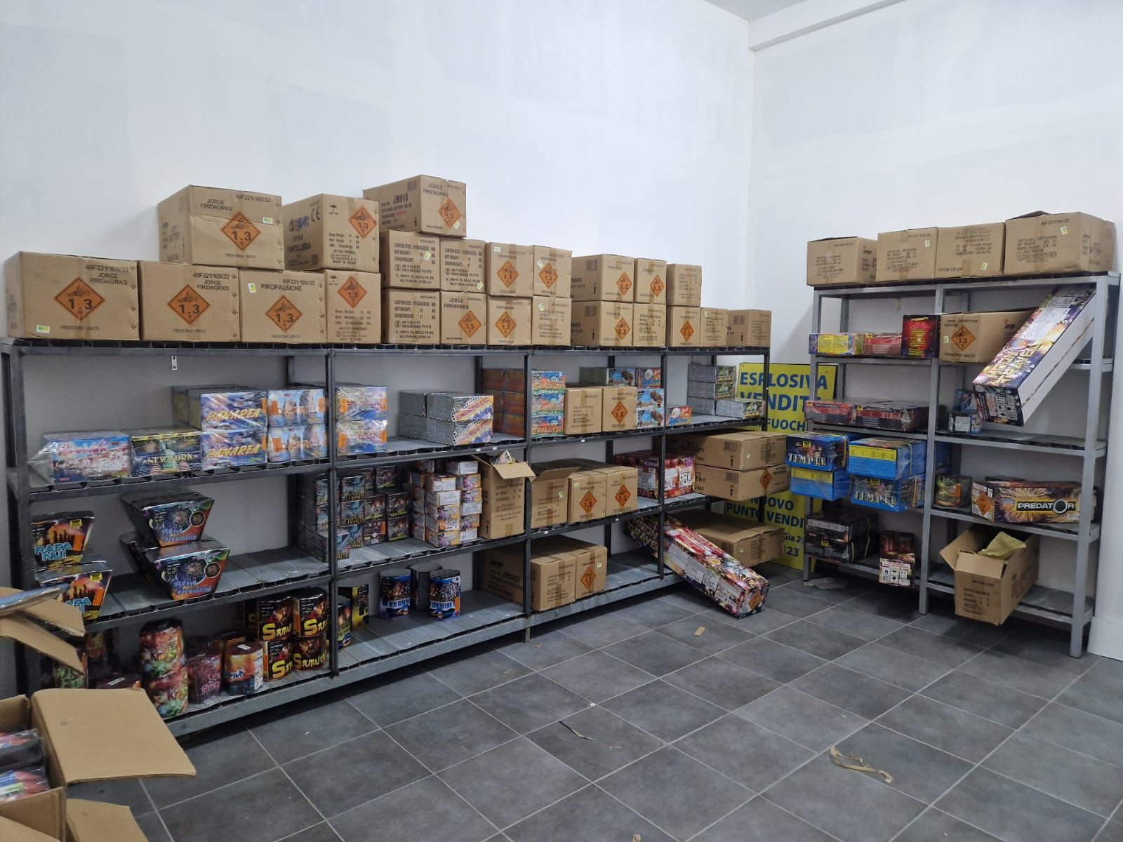 Una stanza piena di scaffali pieni di scatole di fuochi d'artificio.