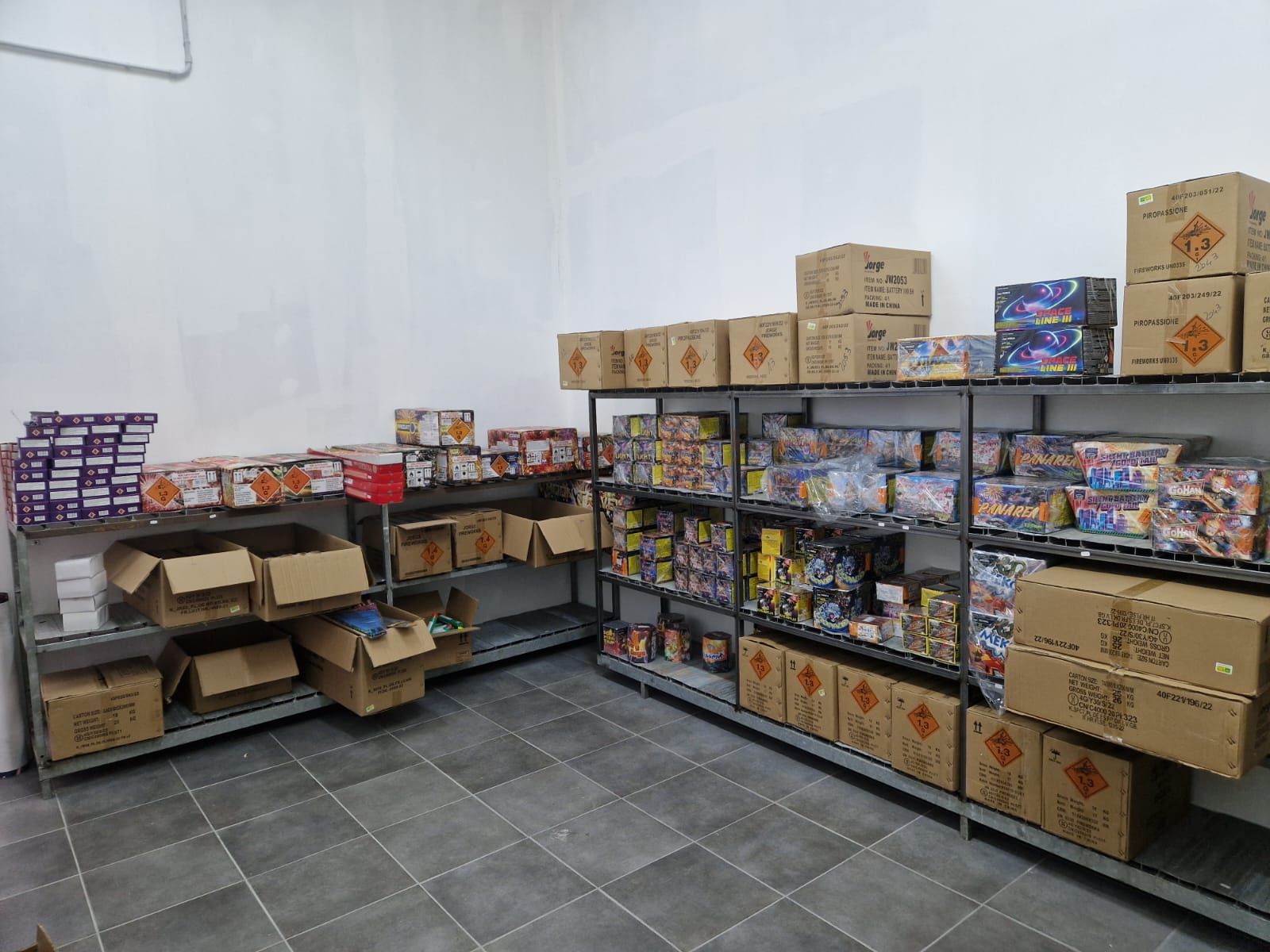 Una stanza piena di scaffali pieni di scatole di fuochi d'artificio.