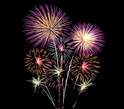 Una serie di fuochi d'artificio colorati esplodono nel cielo notturno.