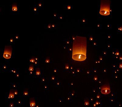 Un gruppo di lanterne fluttua nell'aria di notte.