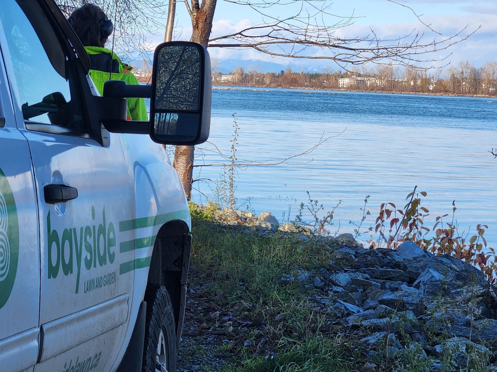 A bayside truck is parked next to a body of water.