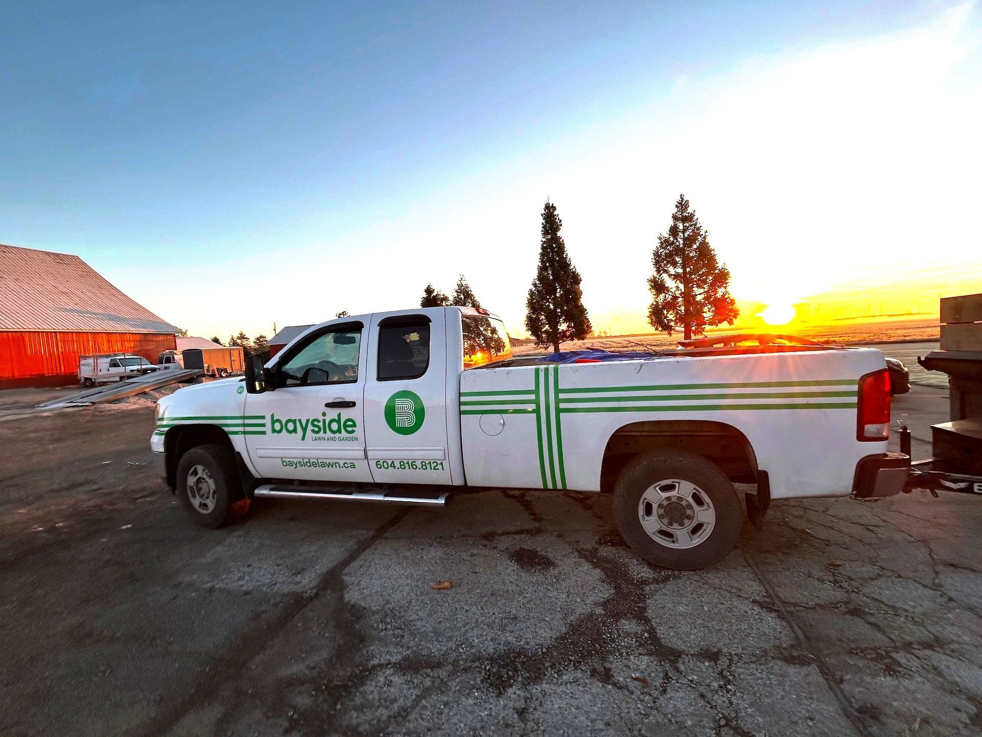 A white bayside truck is parked in a parking lot at sunset.