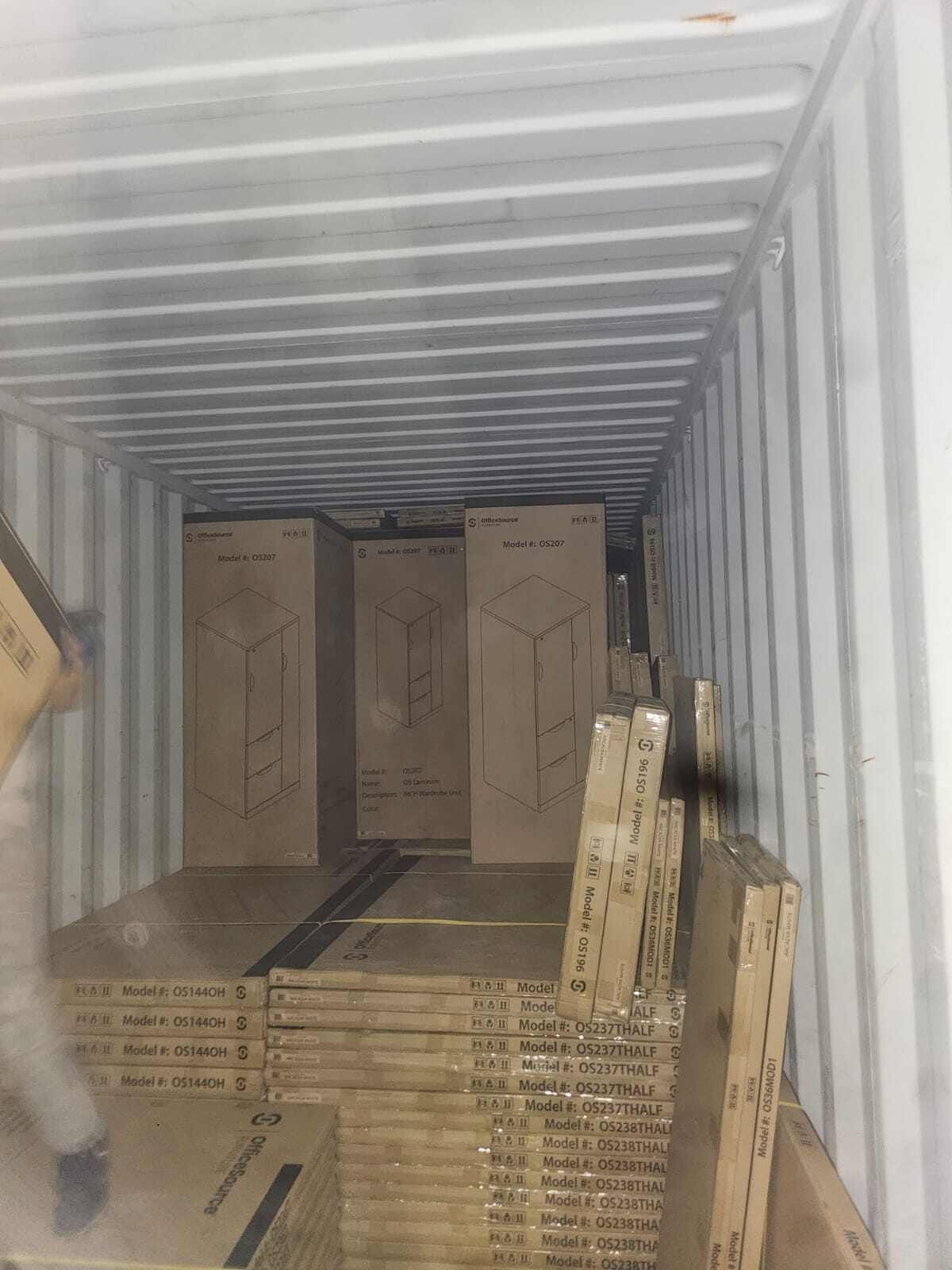 Boxes and wooden boards fill a shipping container.