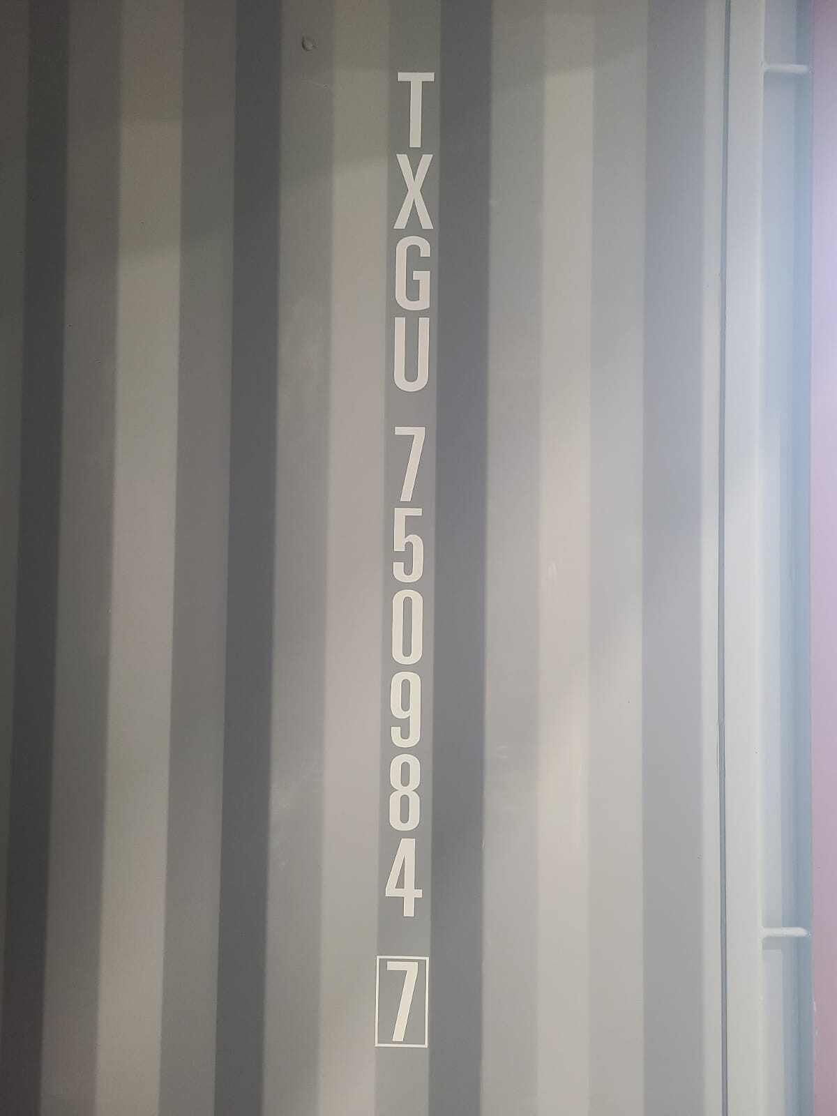 Gray cargo container with white letters and numbers: TXGU 750984 7.