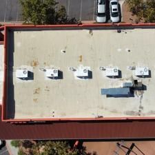 An aerial view of the roof of a building with cars parked on it.