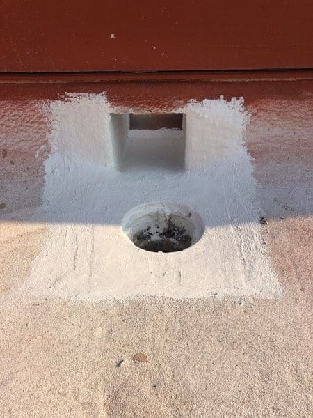 A hole in the ground with white paint on it.