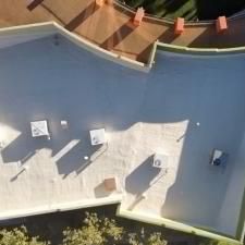 An aerial view of a roof of a building with trees in the background.