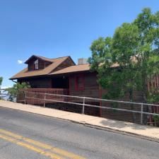A house with a ramp leading to it is on a hill next to a road.