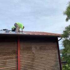 A man is working on the roof of a wooden building.