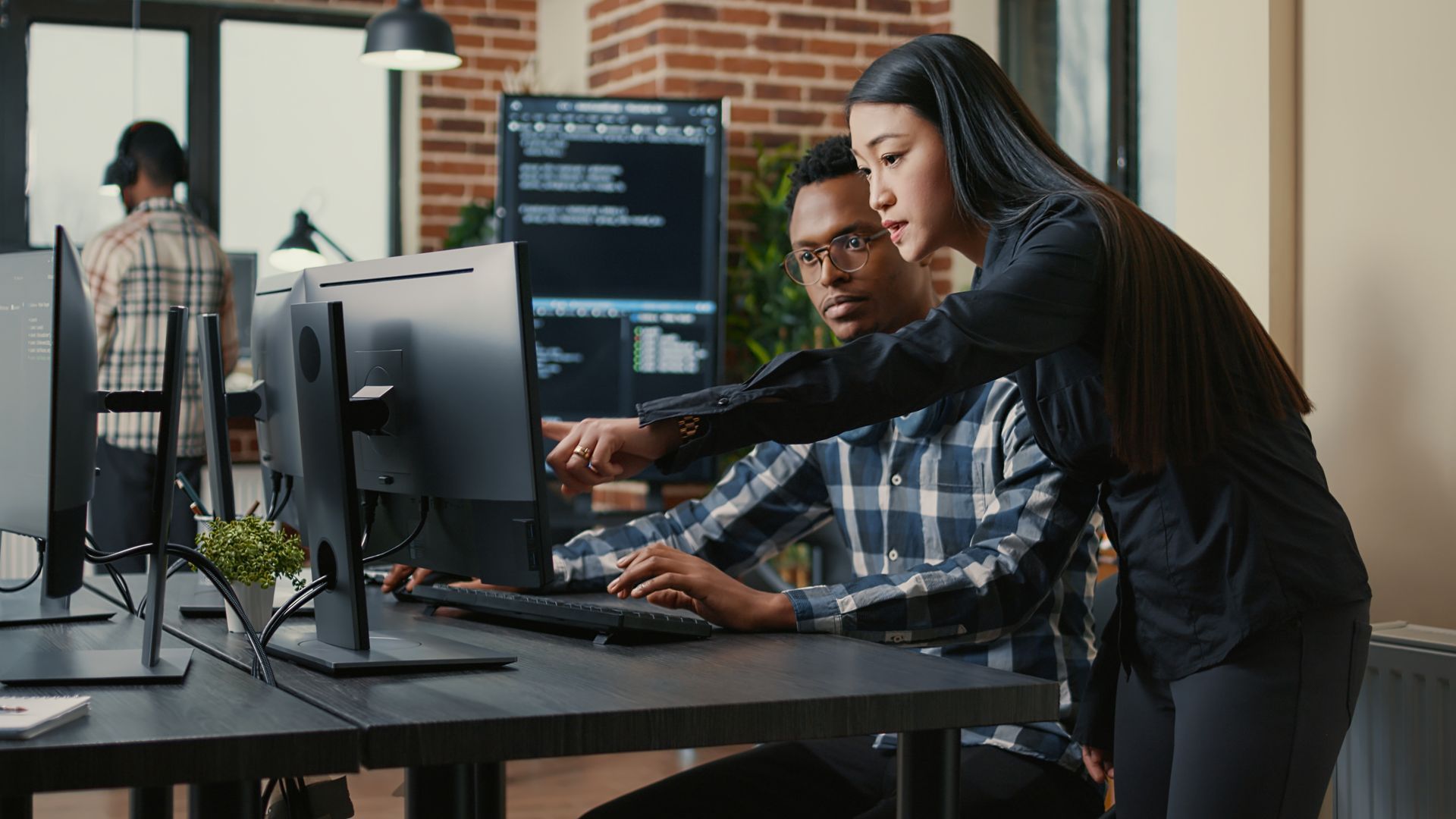 a managed IT team working together on a computer in the office