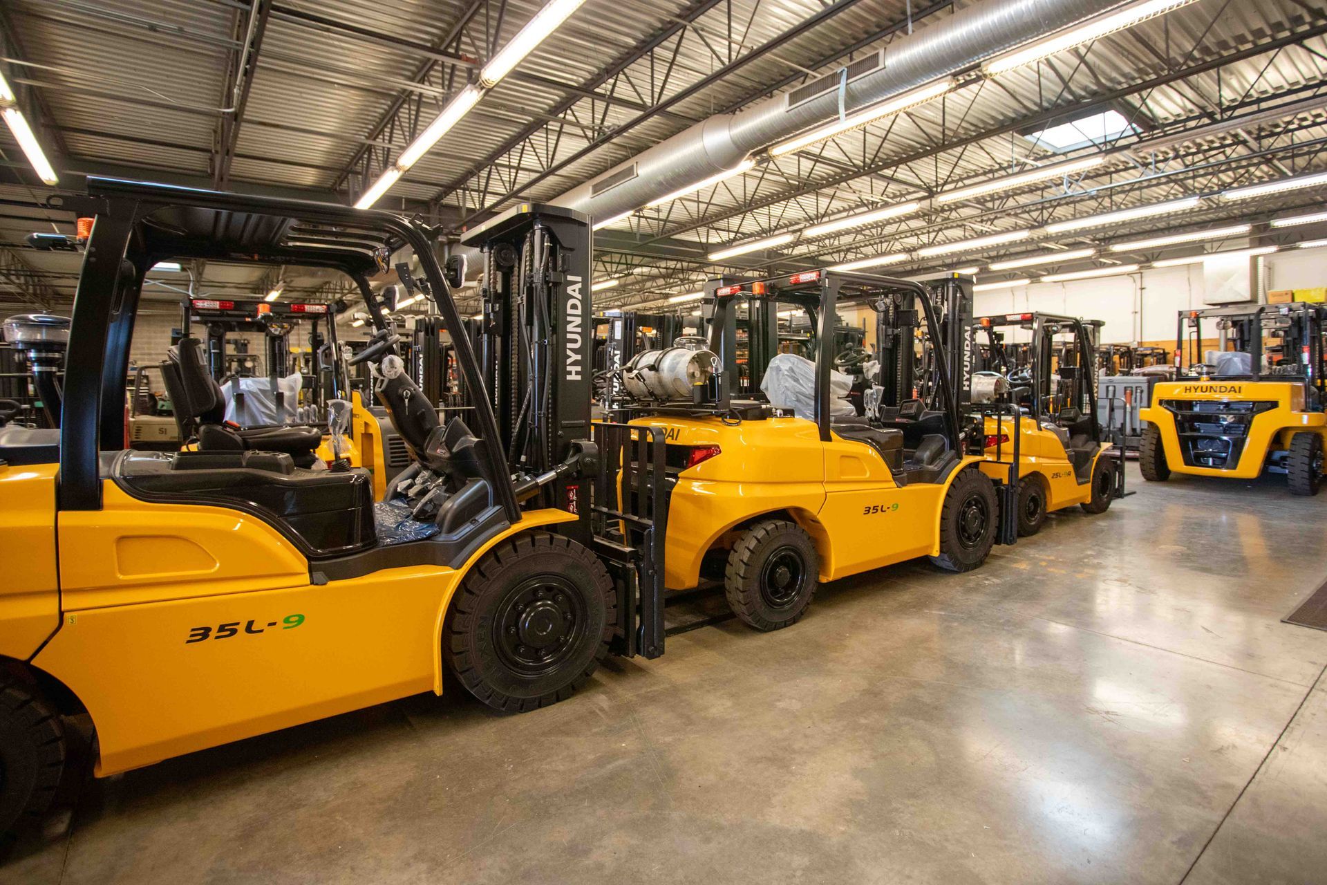 Yellow forklifts lined up inside a warehouse.