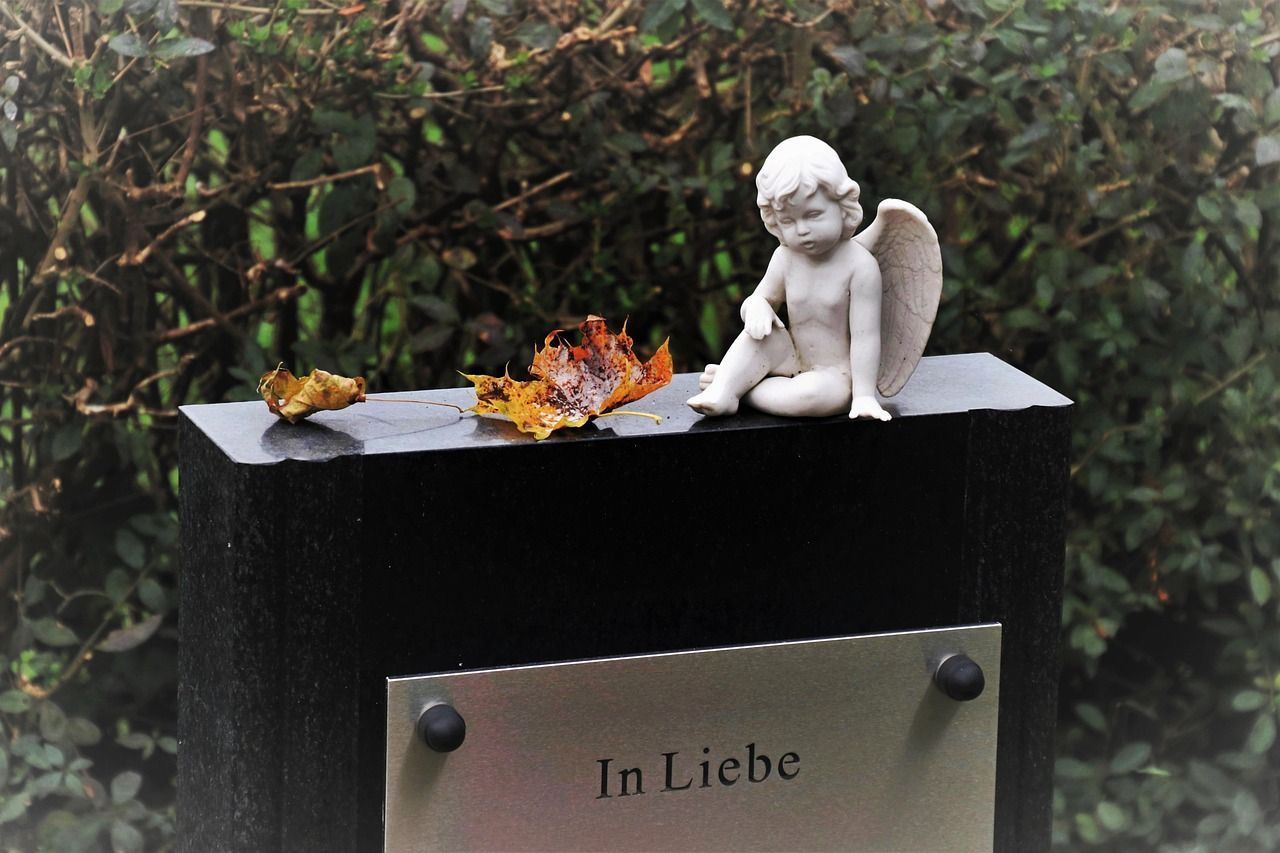 Angel cemetery sculpture symbolizing sadness and remembrance in a graveyard