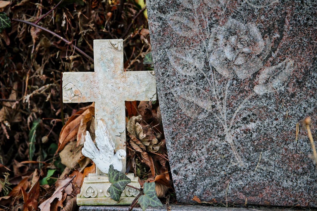 Simple cross tombstone in a graveyard under soft light symbolizing faith, memory, and eternal rest.