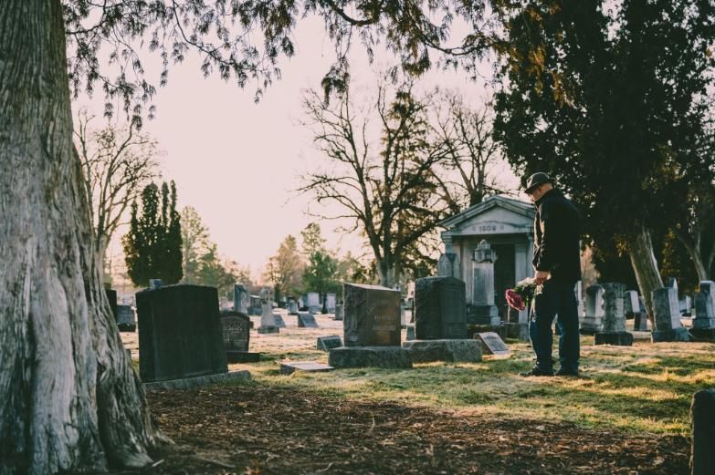 Man placing flowers at gravesite, funeral home and cremations Edinburg, TX