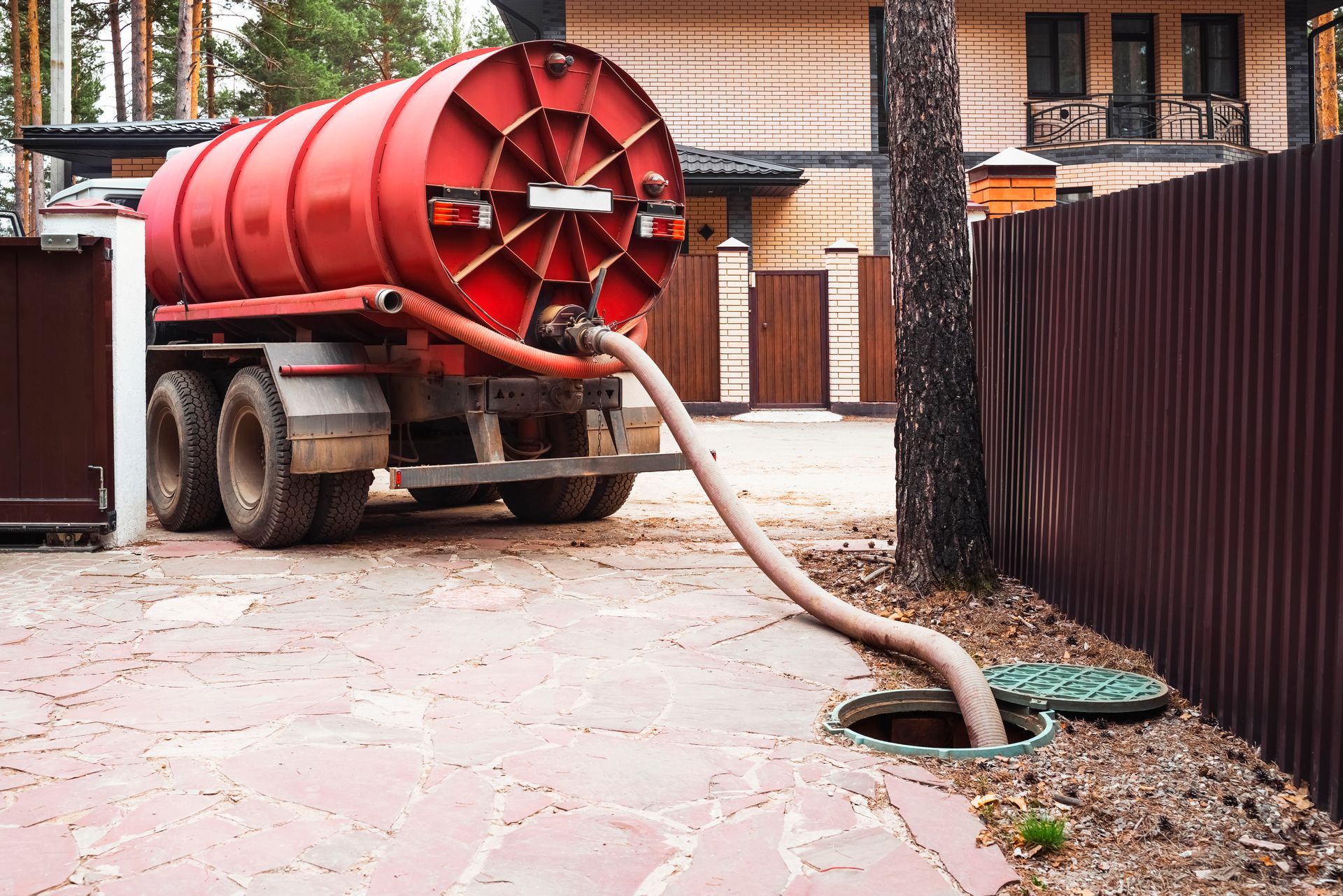 Professional septic tank system pumping service in progress at a residential property.