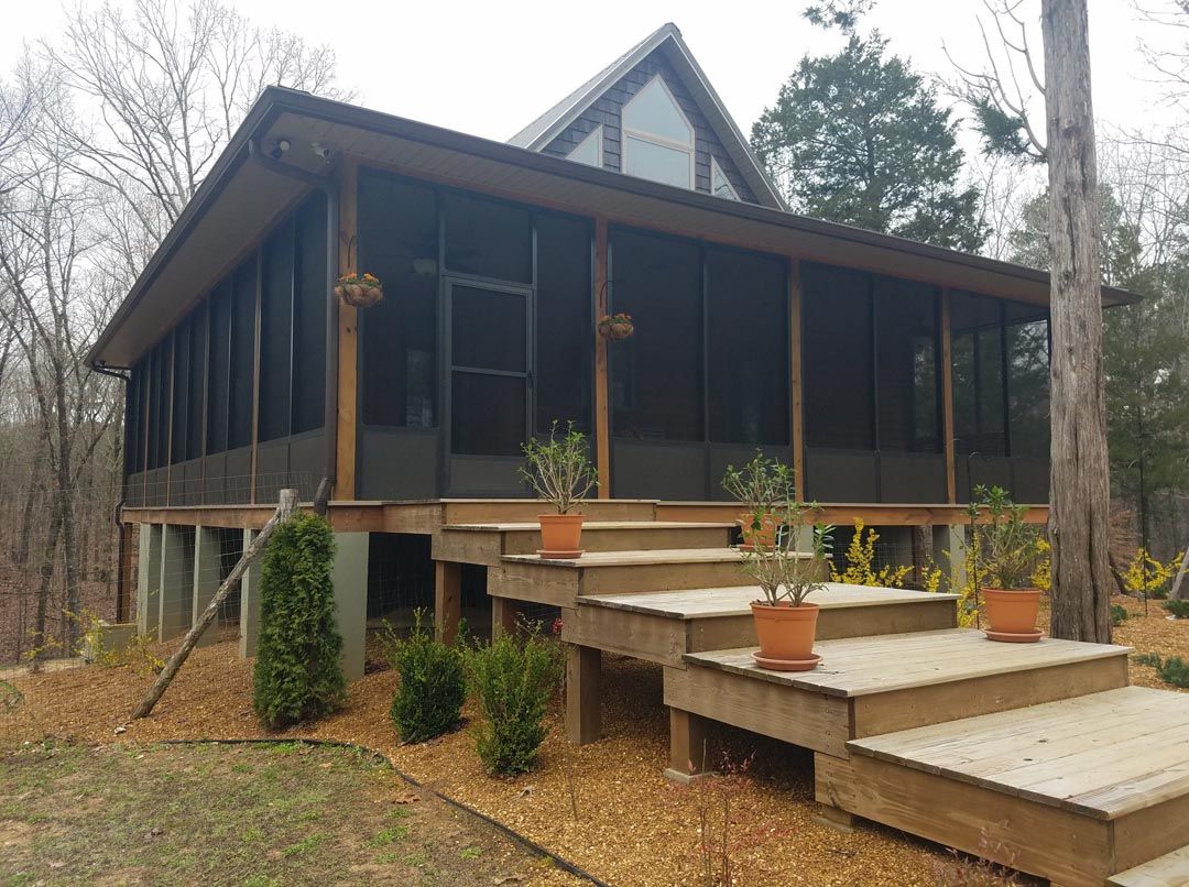 A house with a screened in porch and stairs