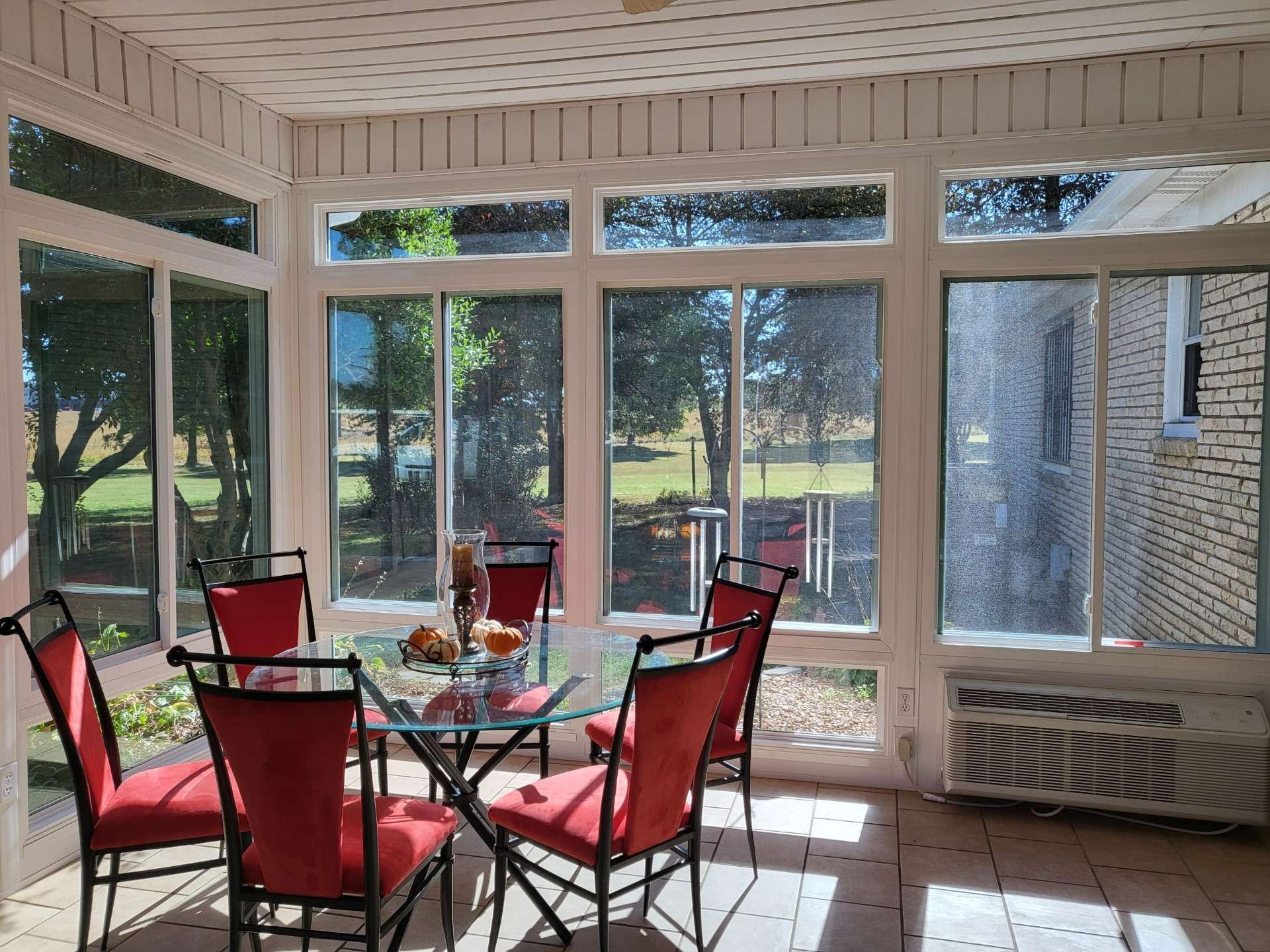 A sunroom with a table and chairs and lots of windows
