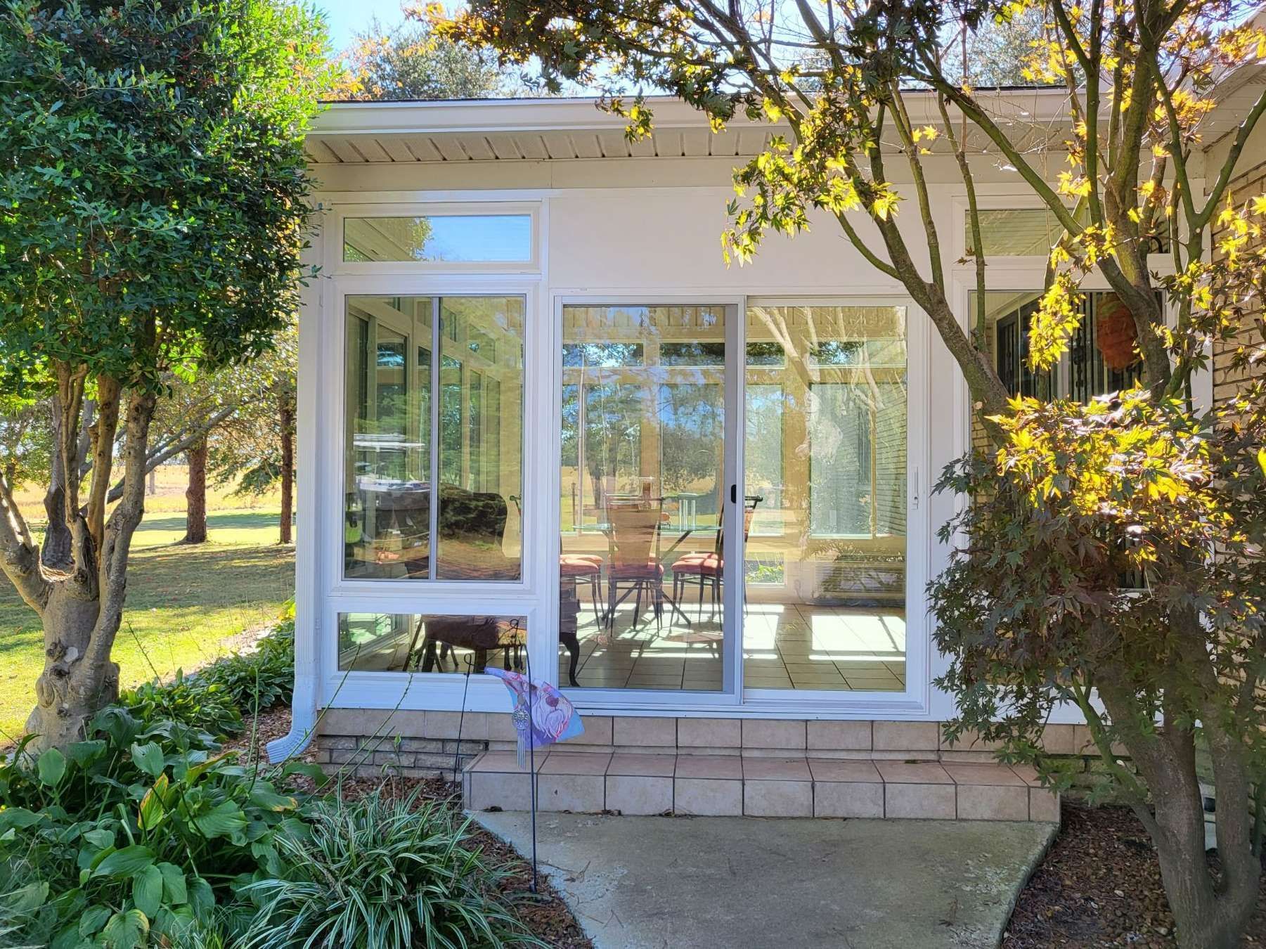 A sunroom with a lot of windows and a sliding glass door