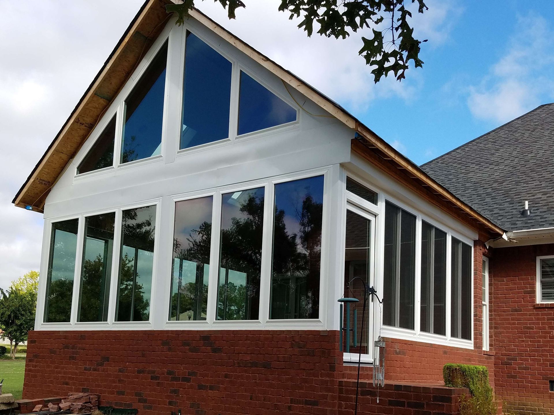 A brick house with a screened in porch on the side