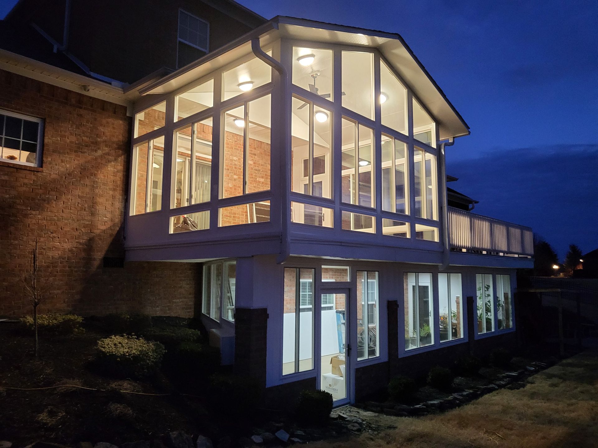 A house with a screened in porch and a truck parked in front of it