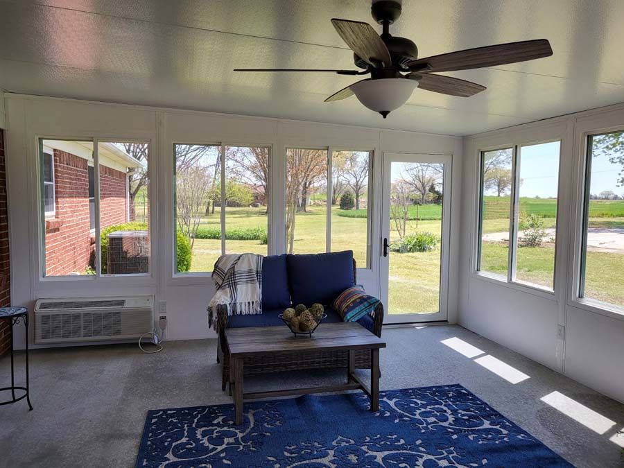 A living room with a couch , table , and ceiling fan