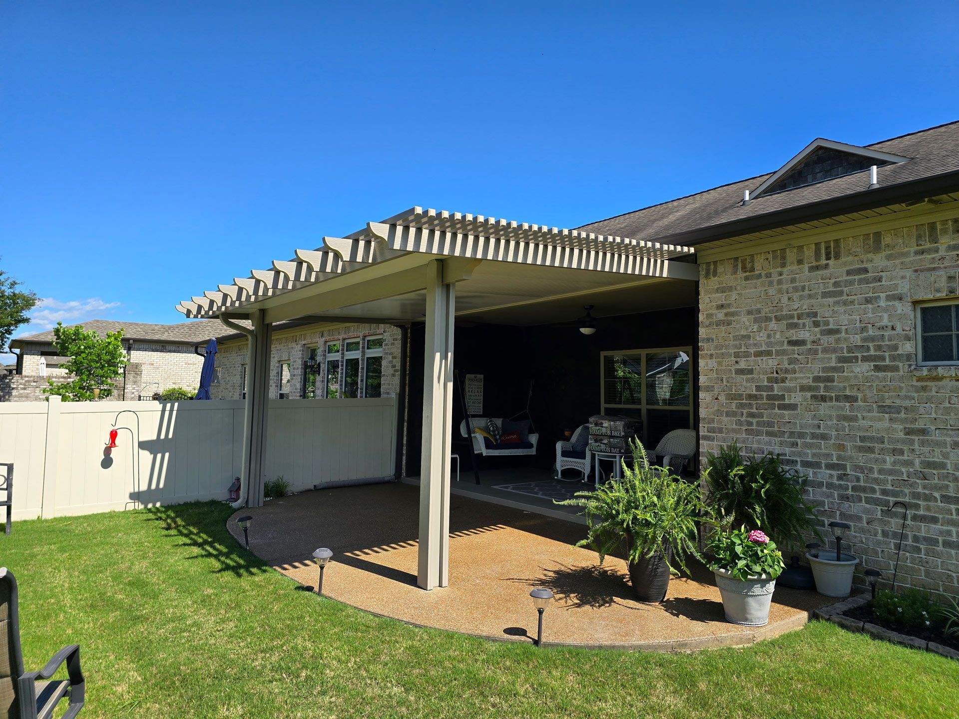 A brick house with a covered patio in the backyard