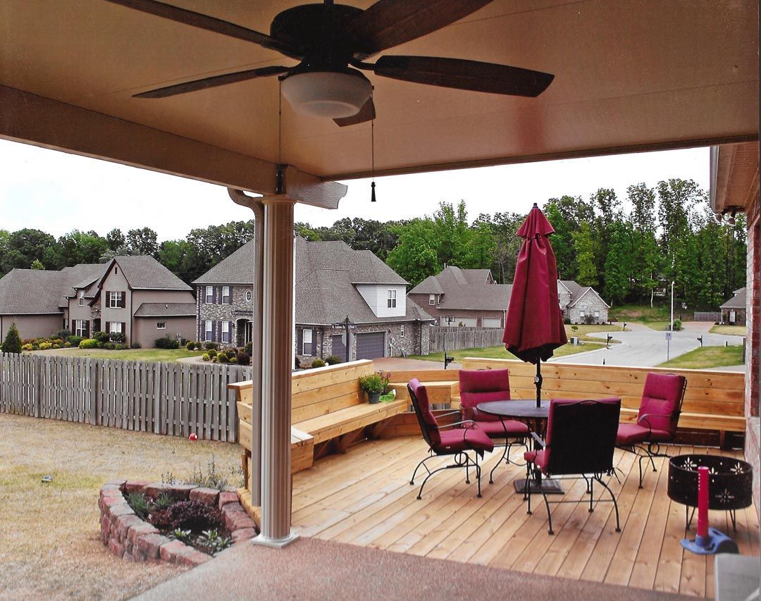 A deck with a table and chairs and a ceiling fan