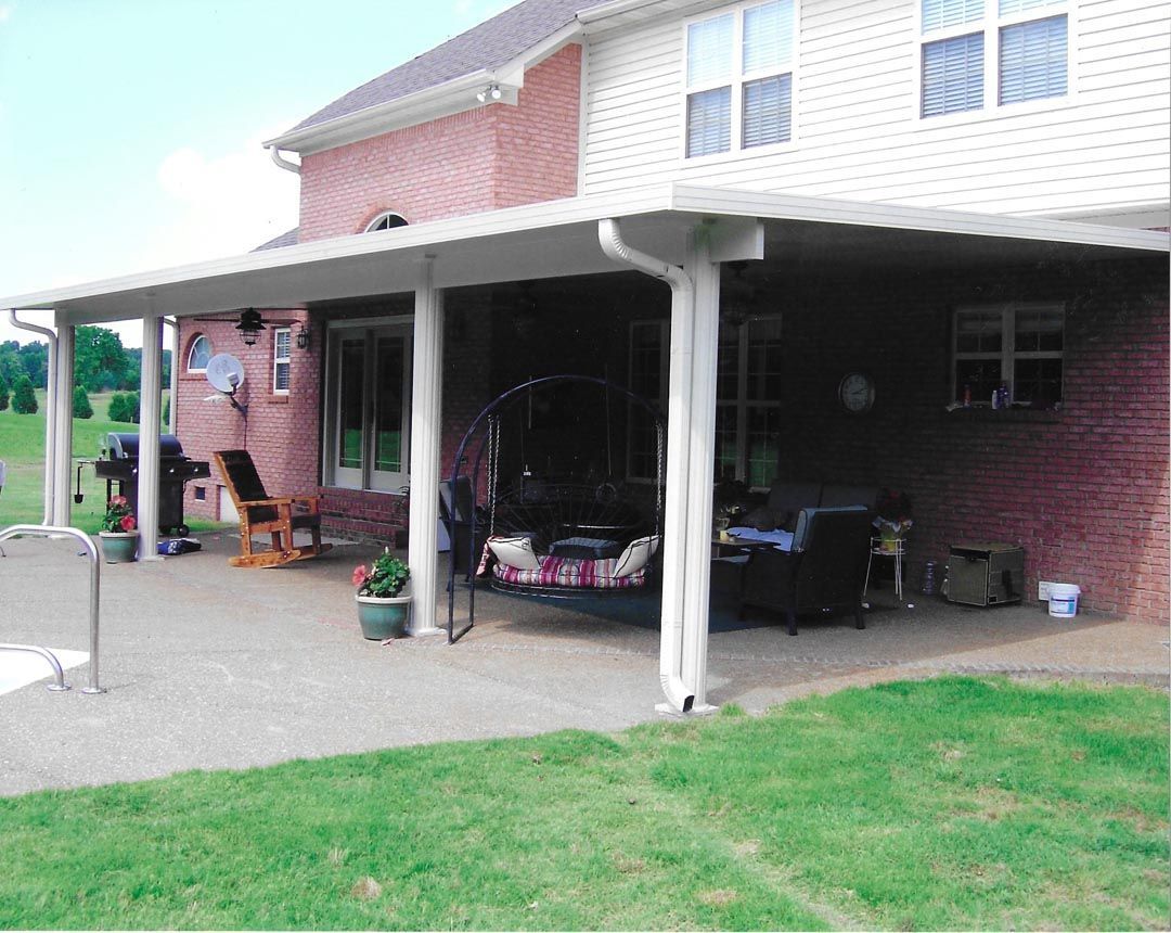 A large brick house with a covered patio in front of it