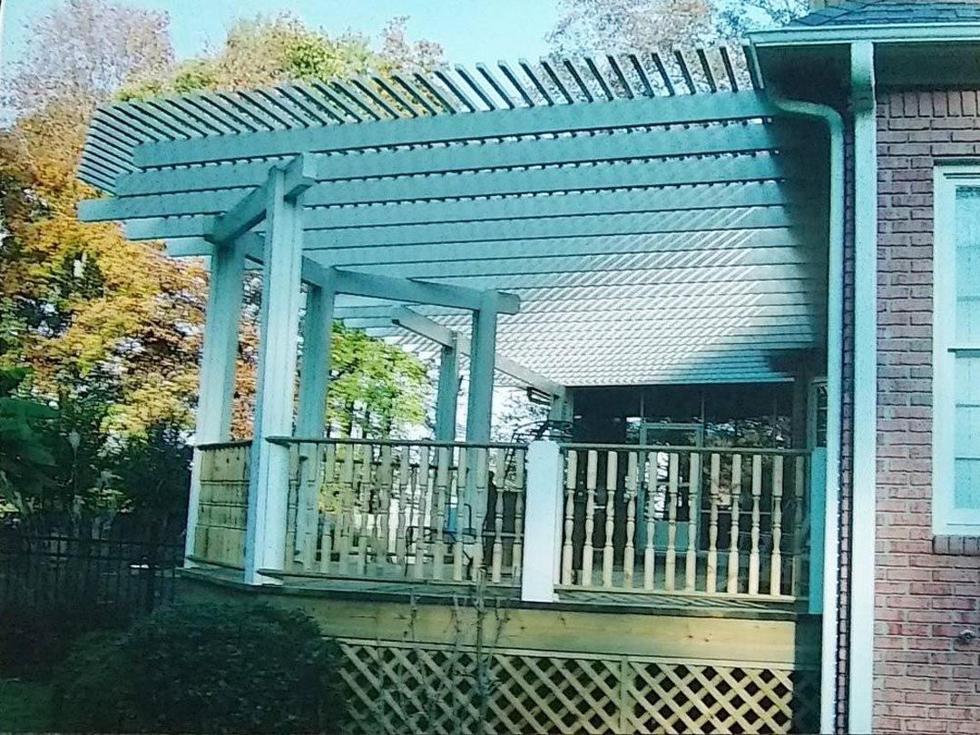 A brick house with a pergola on the side of it