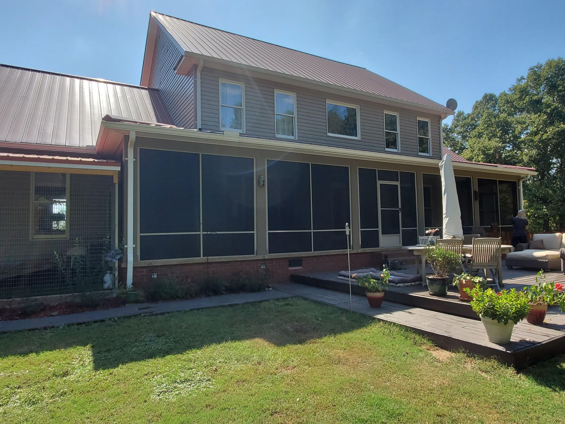 A large house with a screened in porch and a patio