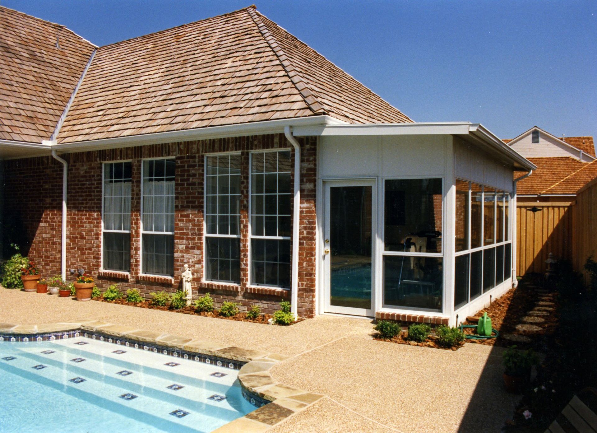 A house with a screened in porch and a swimming pool