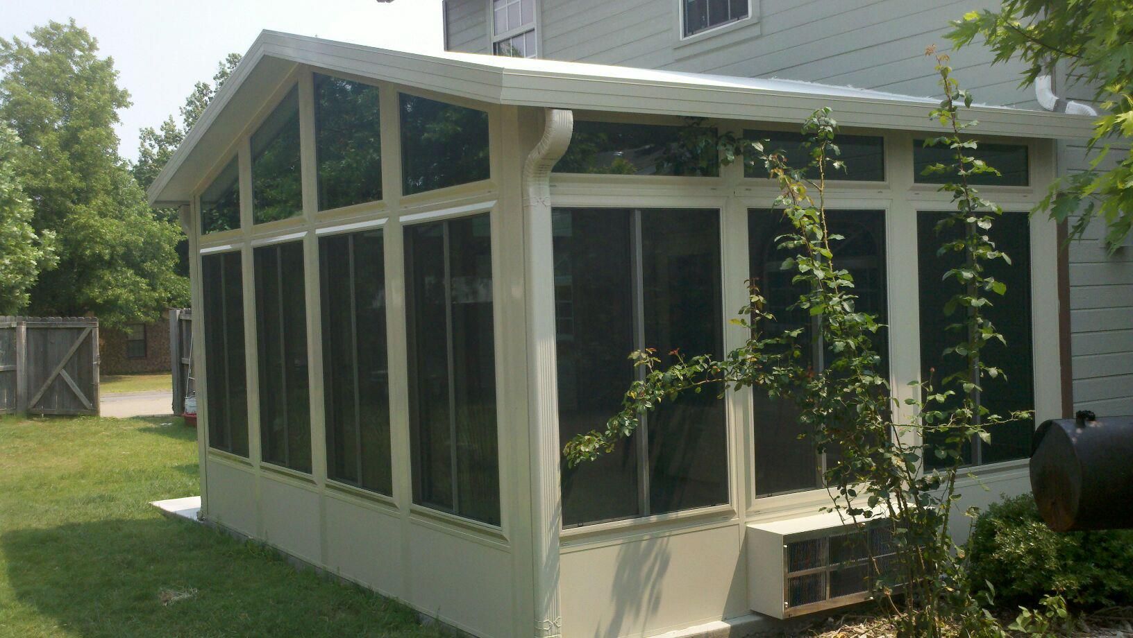 A screened in porch is attached to the side of a house