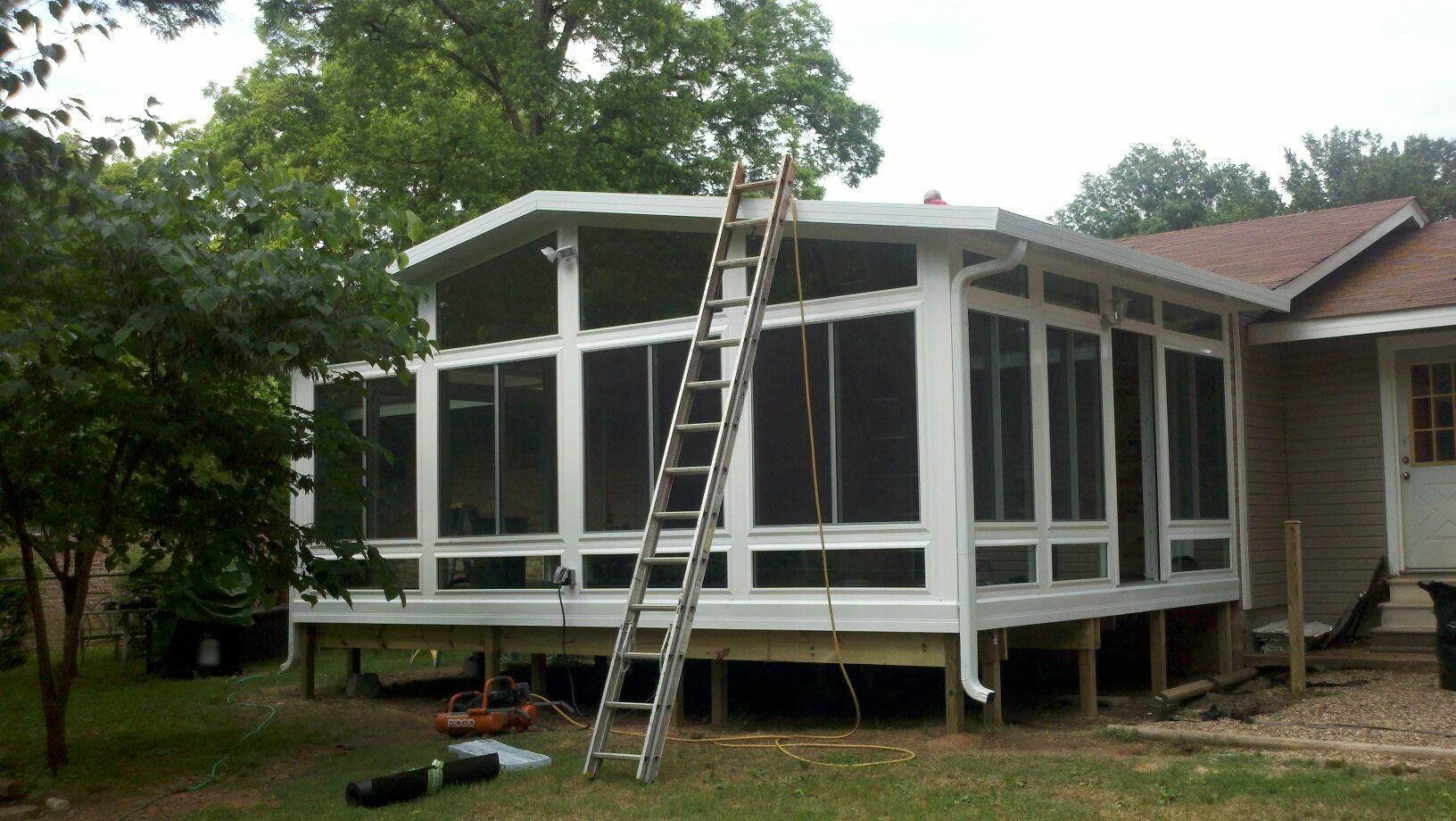 A screened in porch with a ladder attached to it