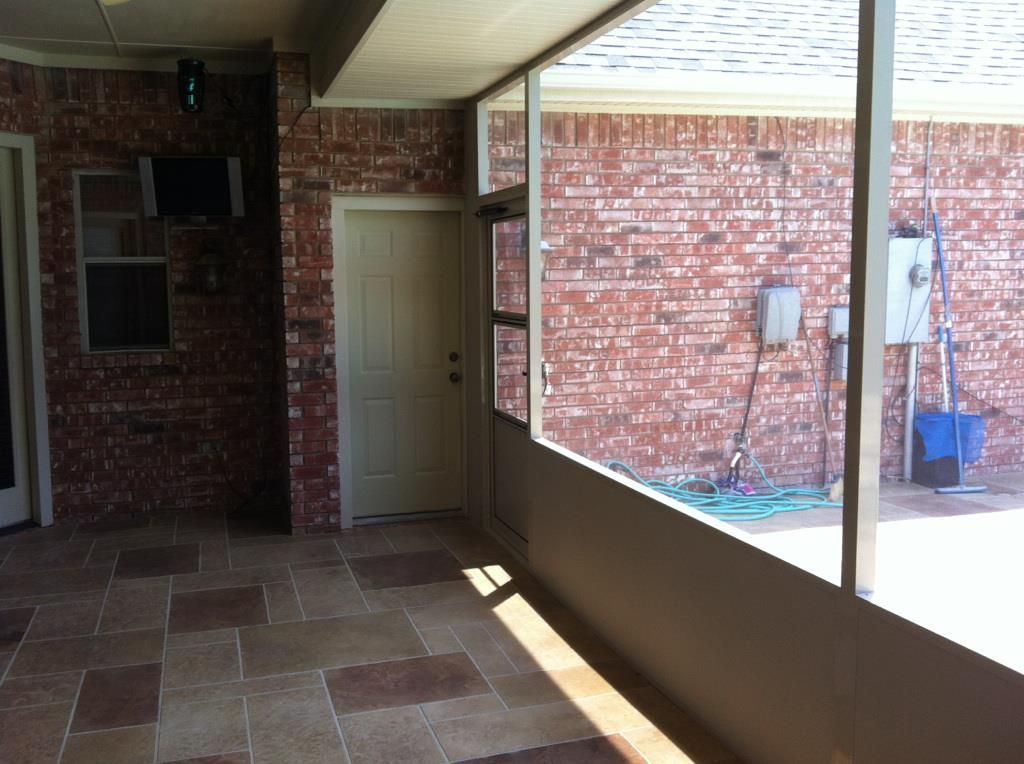 An empty room with a brick wall and a white door