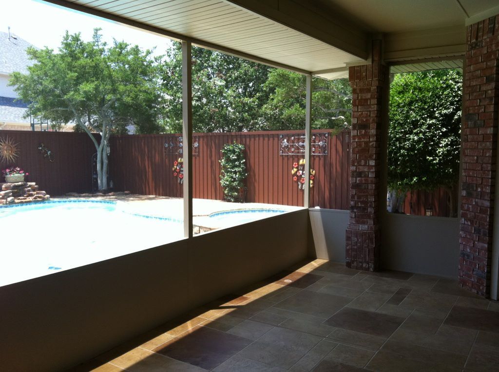 A patio with a view of a pool and a fence