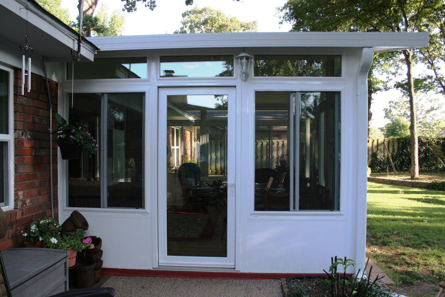 A white sunroom with a sliding glass door