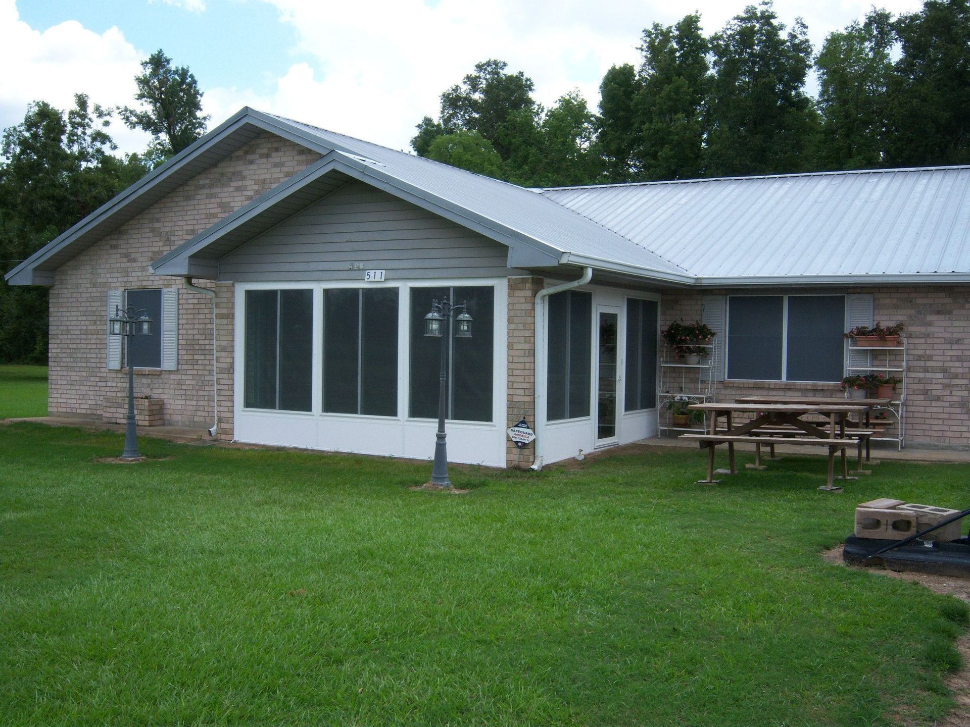 A house with a screened in porch and a picnic table