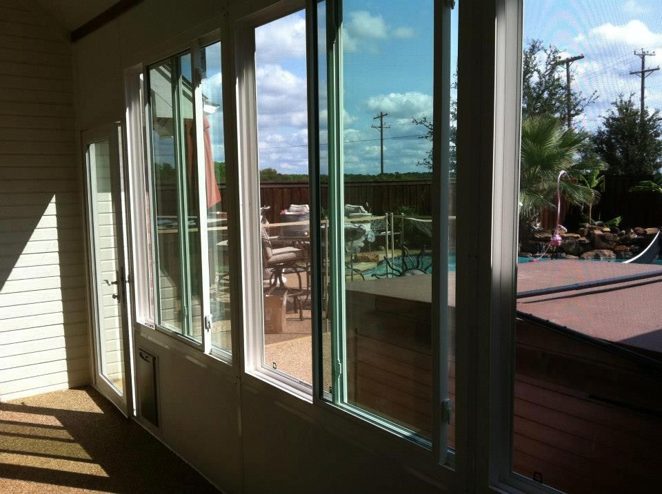 A room with a lot of windows and a pool in the background