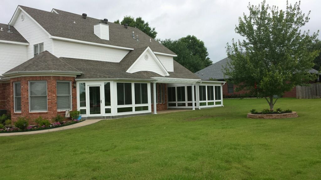 A large brick house with a large screened in porch