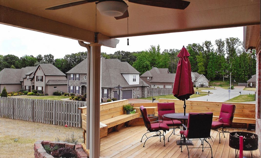 A deck with a table and chairs and a ceiling fan