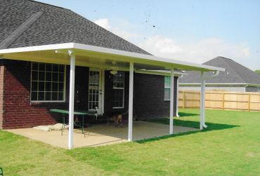 A brick house with a covered patio in the backyard